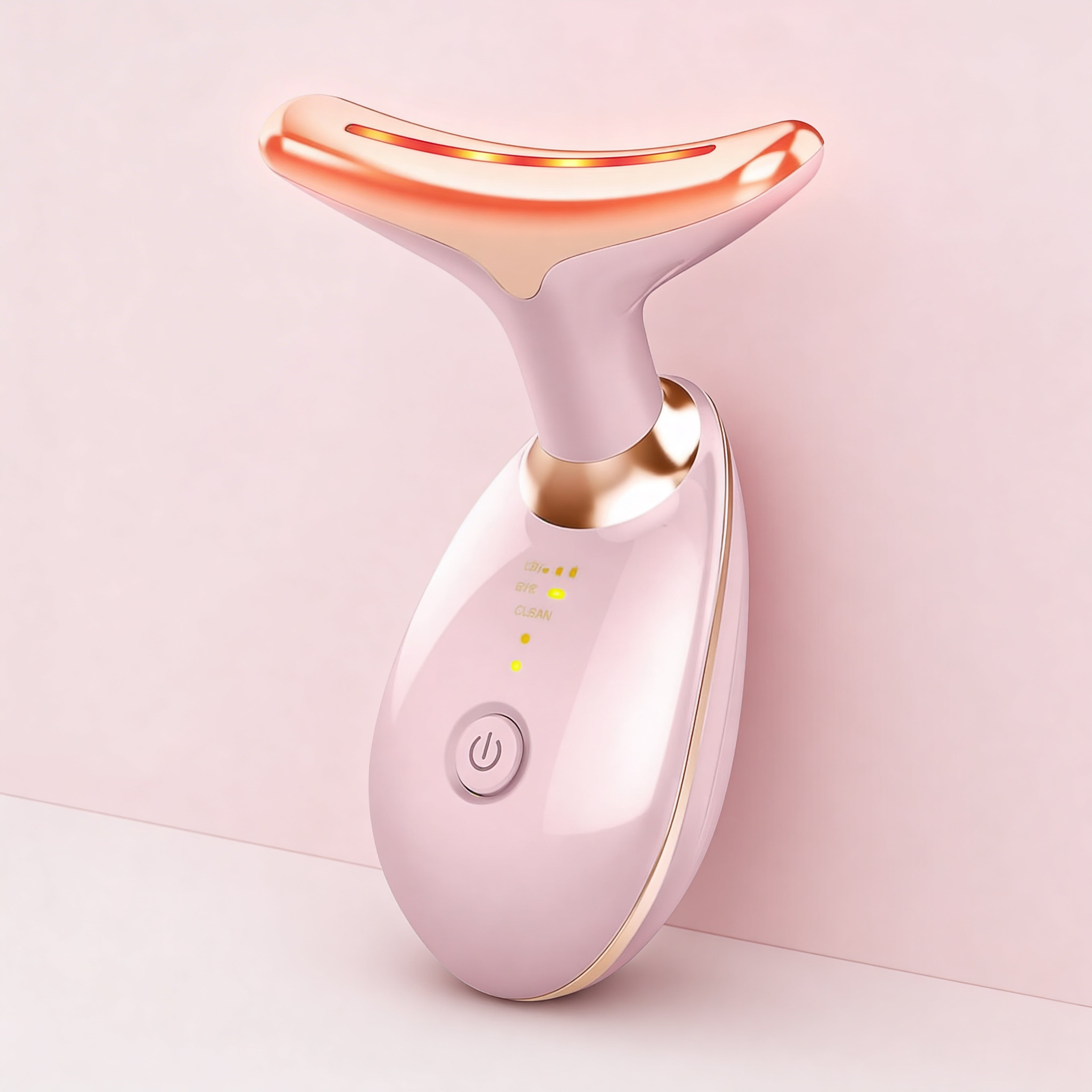 Pink and gold facial device on a light pink background