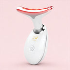 White and red skincare device on a pink background