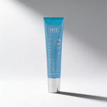 Blue skincare tube labeled 'SHE' on a gray background