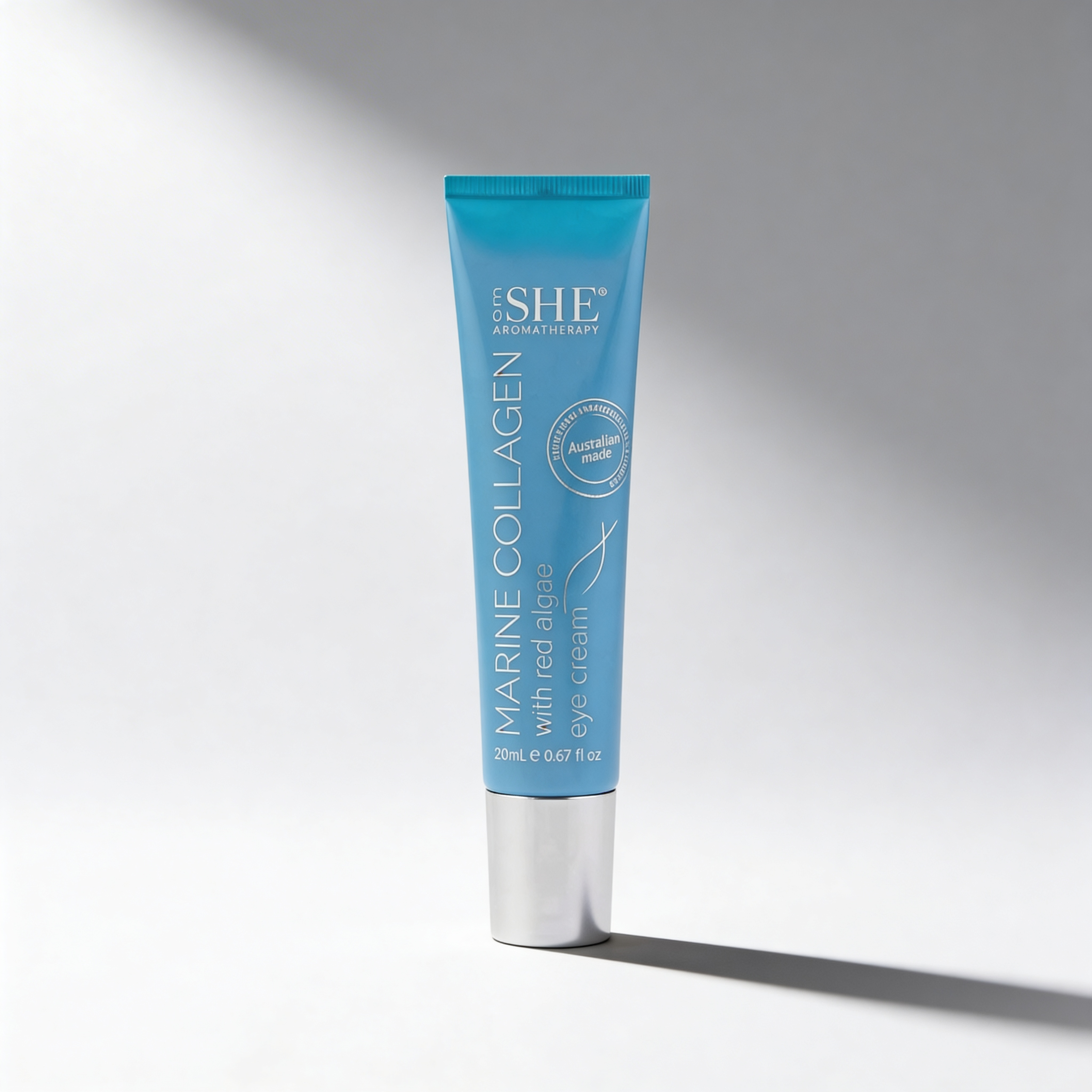 Blue skincare tube labeled 'SHE' on a gray background