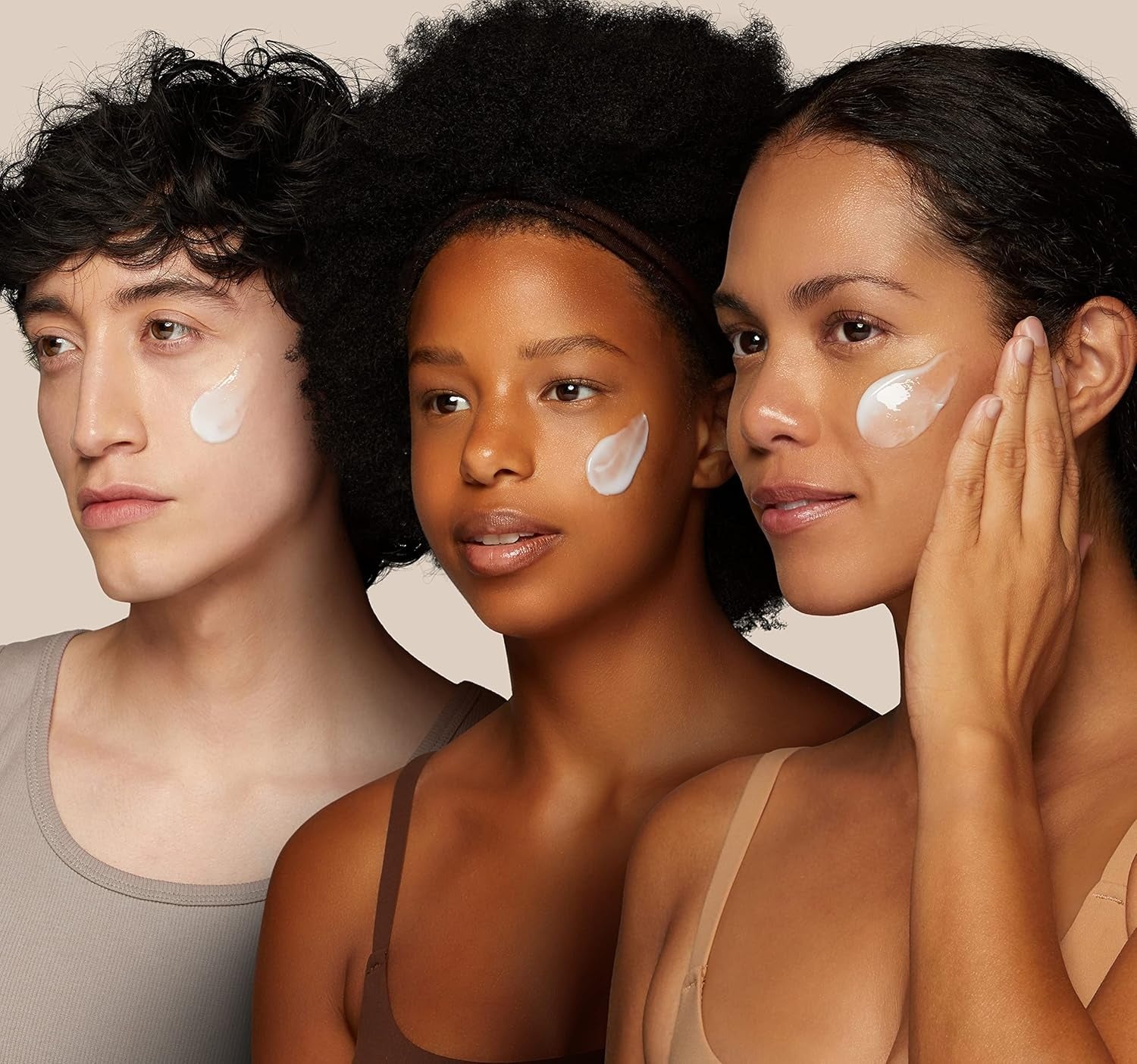 Three people with cream applied to their faces against a beige background